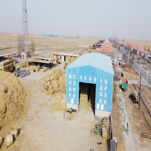 宁夏环恒草毯科技有限公司厂房外景，现代化工业建筑，绿色植被环绕，蓝天白云背景