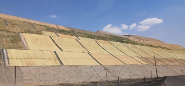 矿山生态修复复绿草毯产品展示，绿色草毯整齐排列，自然光照背景